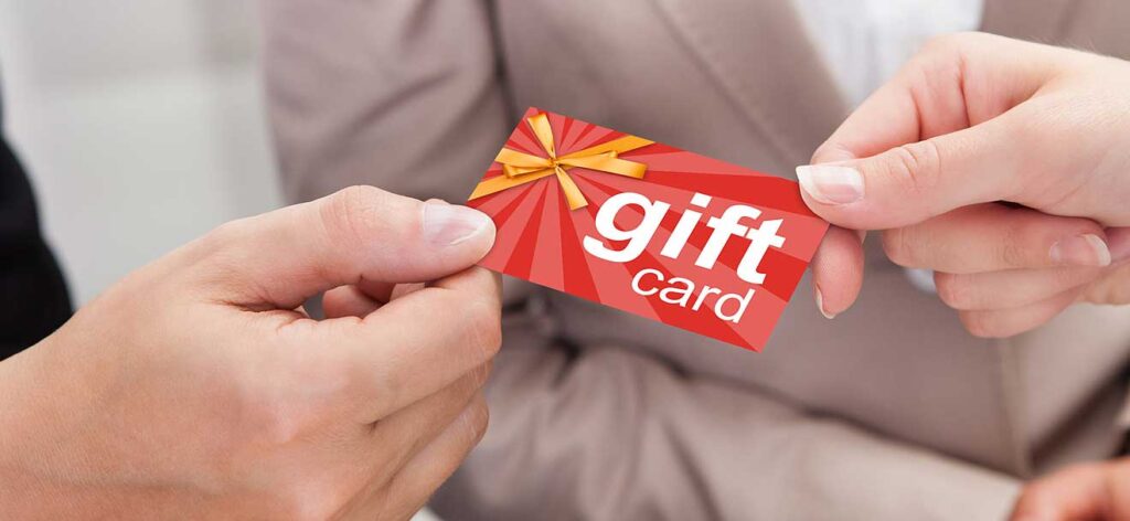 Business woman giving a gift card to a colleague.